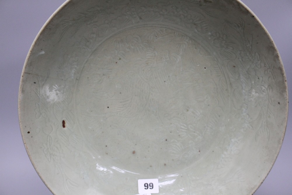 A Chinese Ming celadon dish, Zhangzhou kilns, c.1580-1620, incised with fish and water plants, diameter 38.5cm, height 8cm